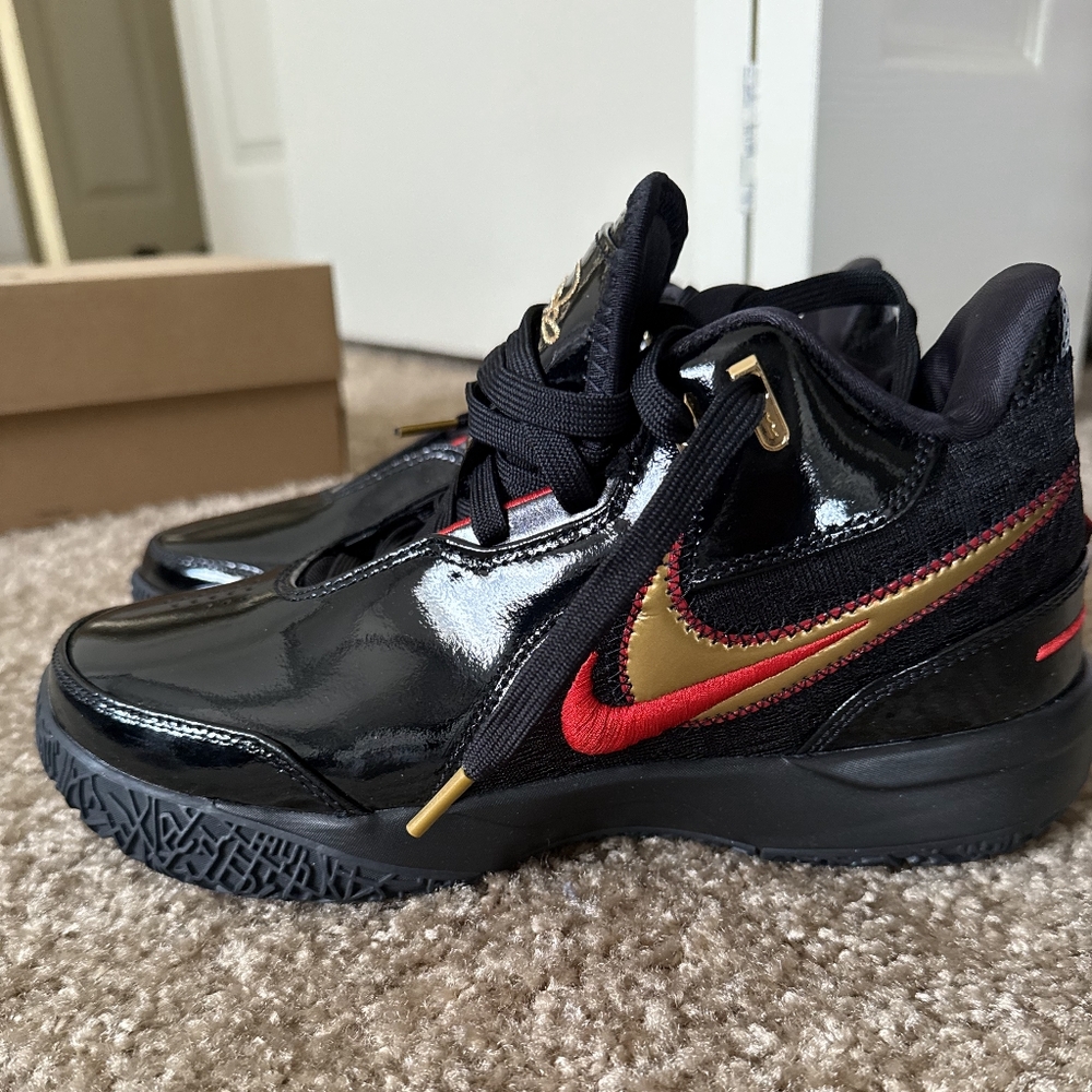 Nike LeBron NXXT GEN AMPD Black and Gold Sneakers with Red Accents